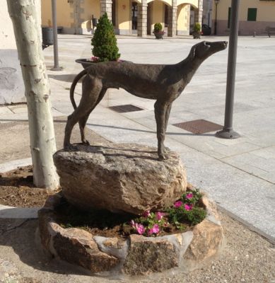 Hound bronze statue in a public square in a Spanish village